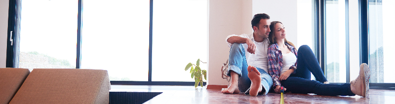 Couple measuring the floor in their house.